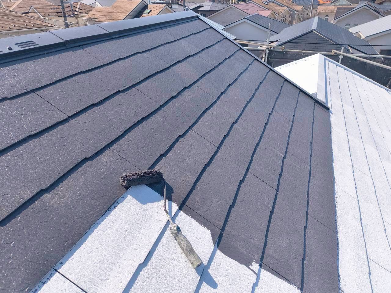 白い屋根に黒色の塗料で中塗り